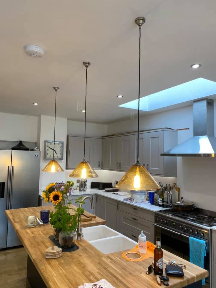 Open-plan kitchen with hanging pendant lights, recessed spotlights and a skylight