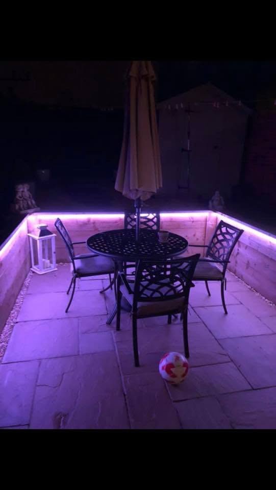 Colour-changing LED lighting around a garden patio at night